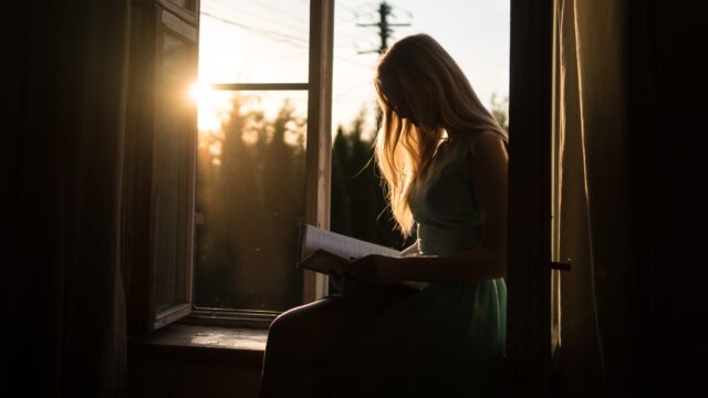 本を読む女性 夕日 窓辺